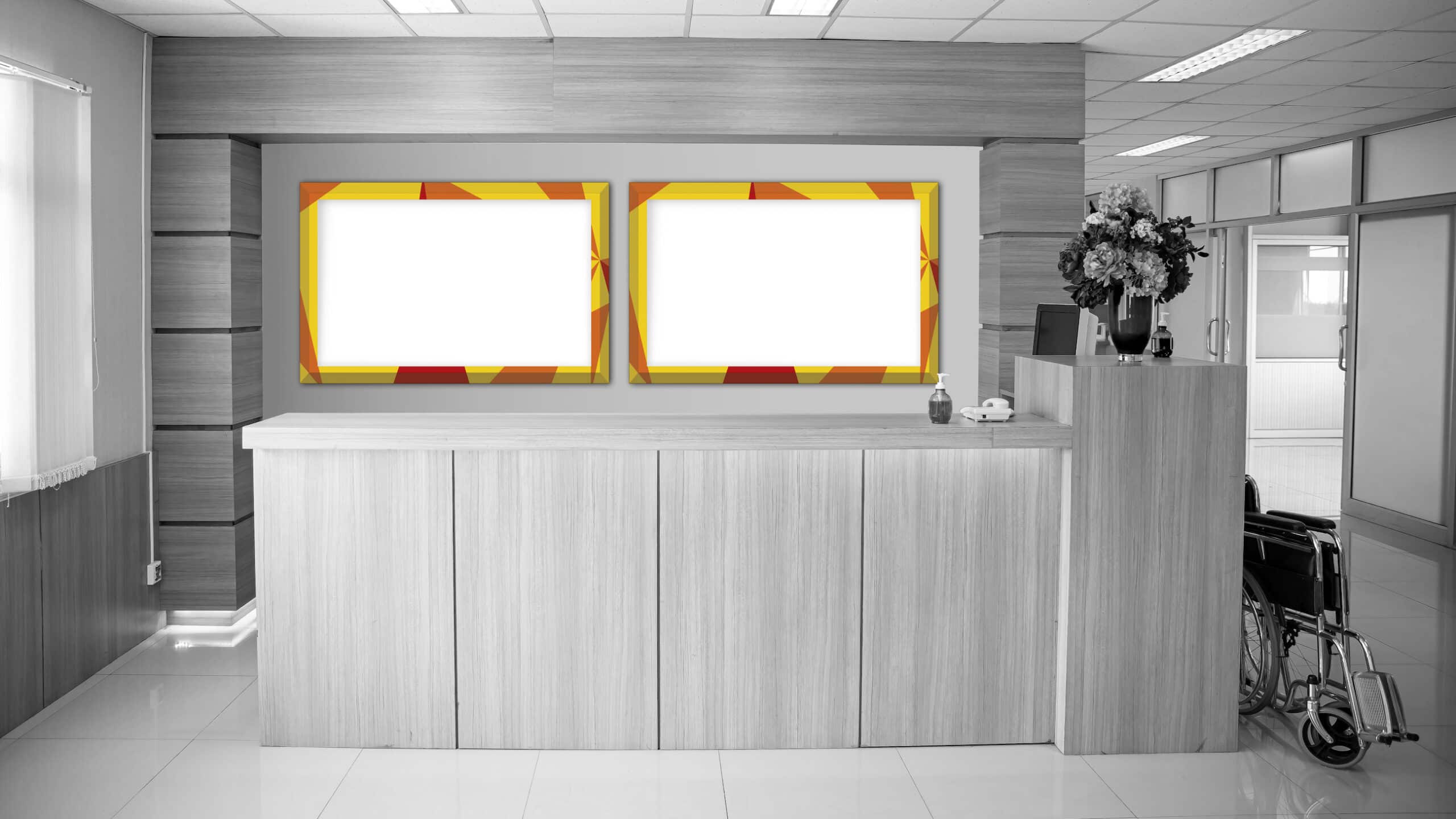Das Bild zeigt zwei Digital Signage Displays als Wandmontage hinter einem Empfangstresen in einer Arztpraxis installiert von SWORKS