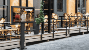 Das Bild zeigt das LG XE4F Serie 49 Professional Outdoor Display mit smart metals Stele vor einem Café von SWORKS geliefert